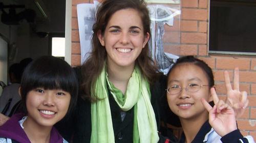 Three international students giving peace signs.